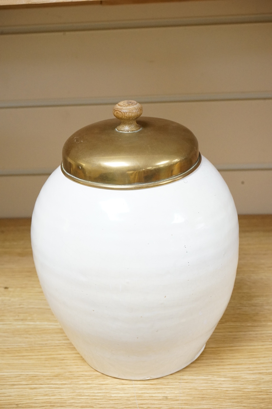 A pottery blue and white figural drug jar with brass cover, 24cm including cover.